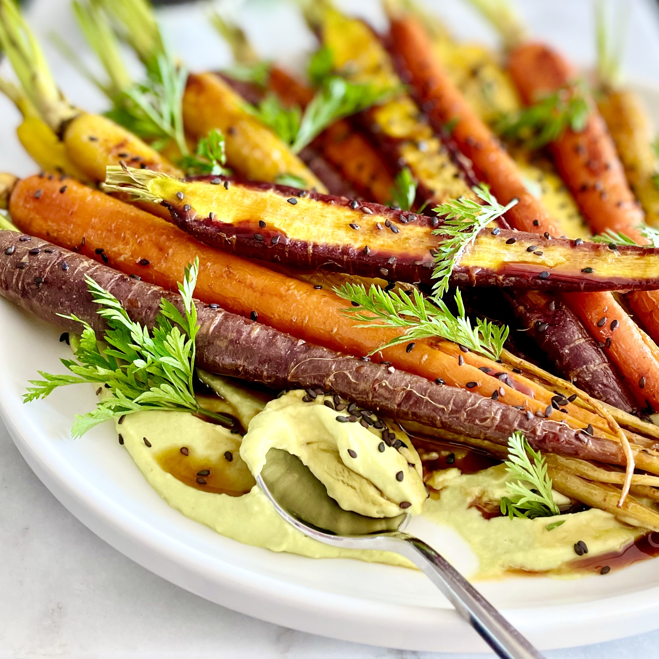 Plate of roasted rainbow carrots on puree