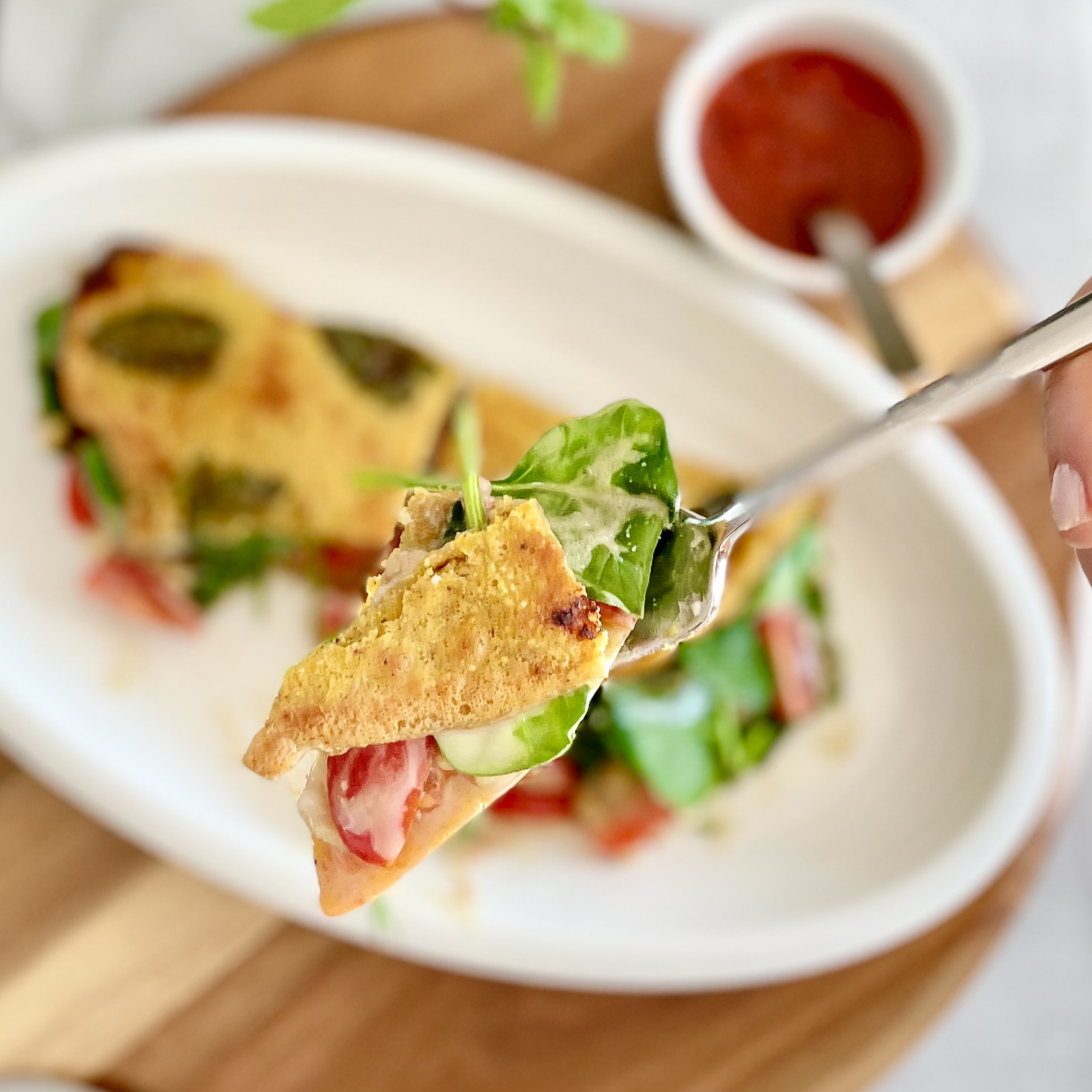 one bite on fork of mediterranean plant-based herbed chickpea omelet