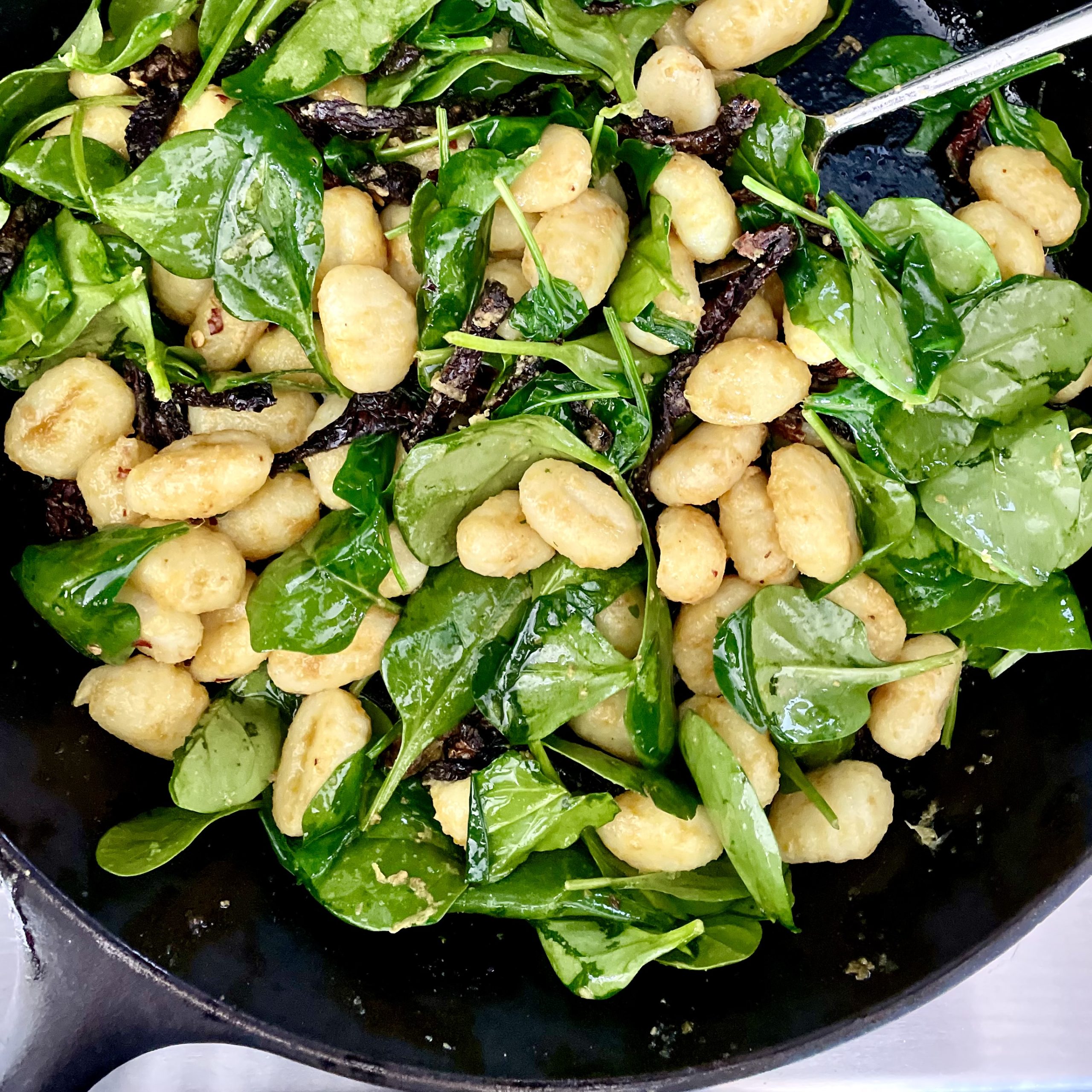 plant-based blt gnocchi_skillet of gnocchi with spinach and sun-dried tomatoes