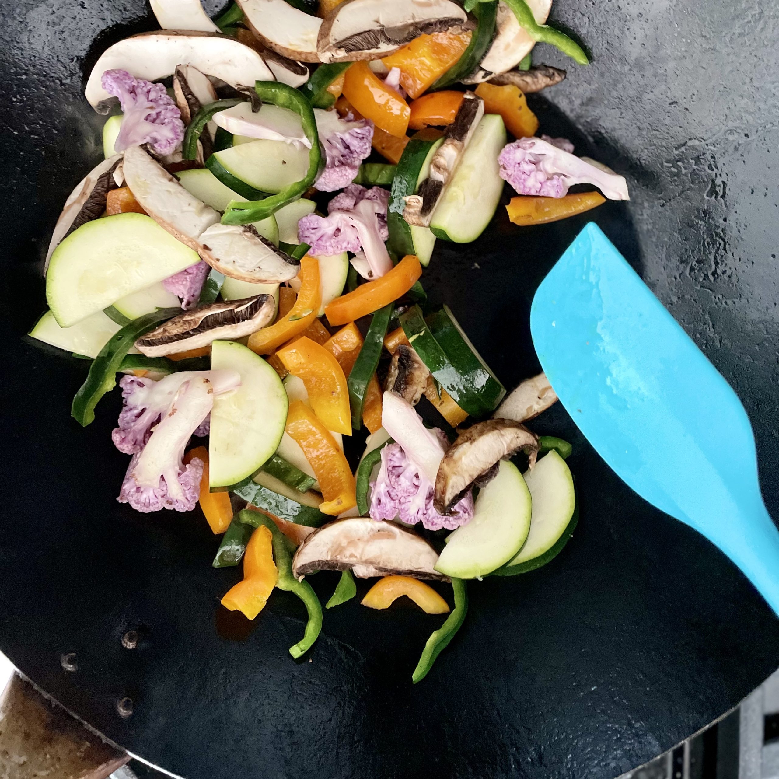 sauteeing veggies in a wok