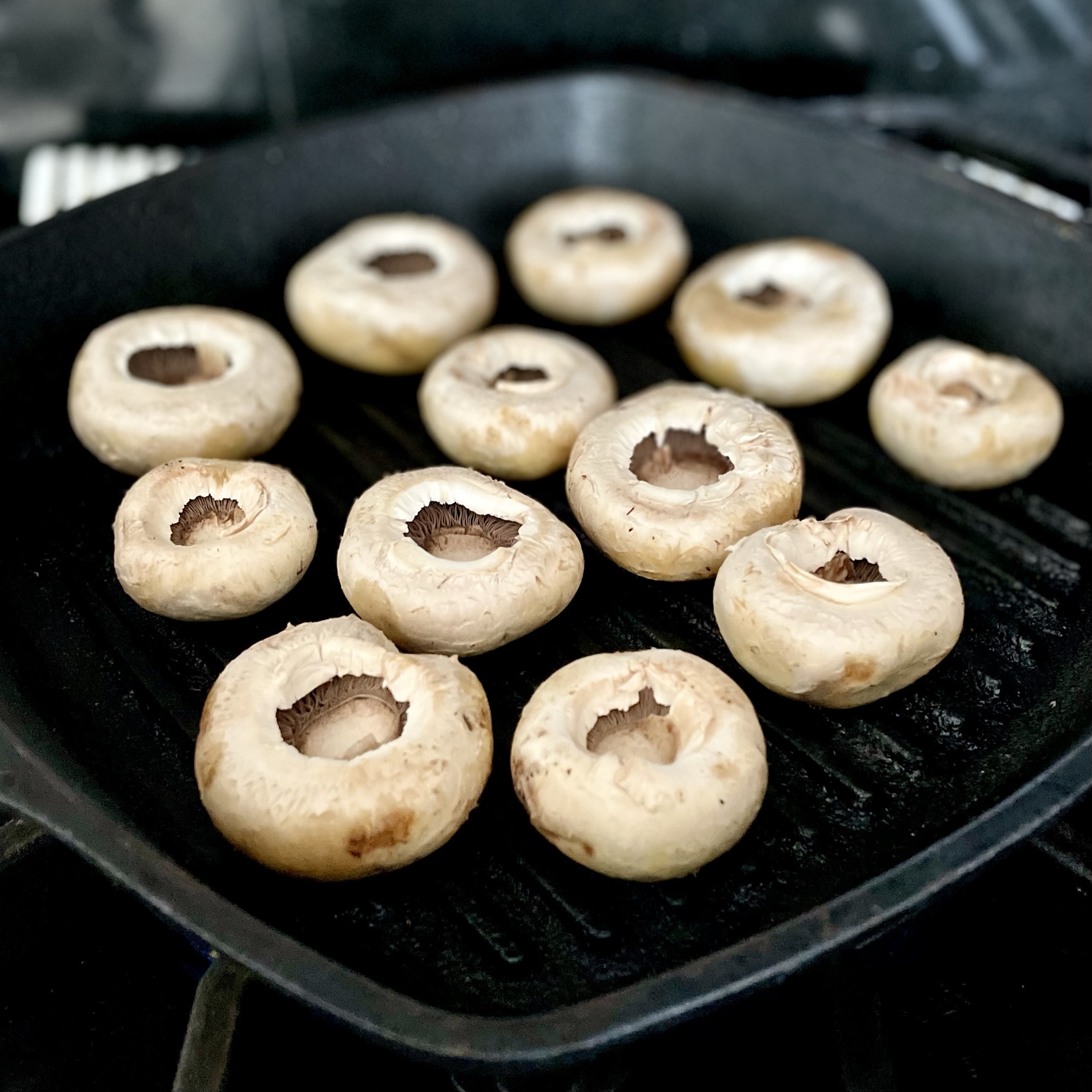 white button mushroom caps on grill pan