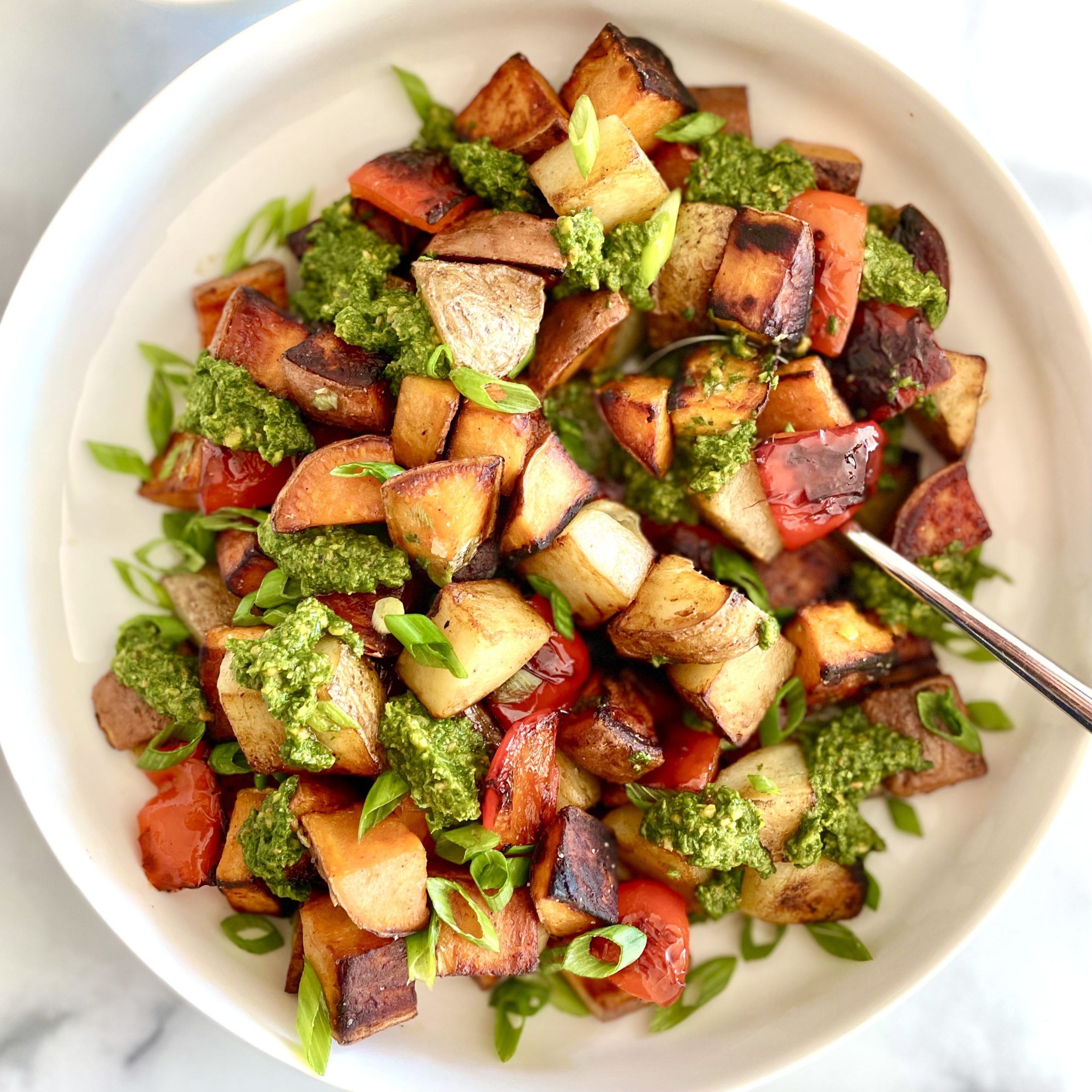 skillet russet & sweet potato hash with arugula pesto with a spoon
