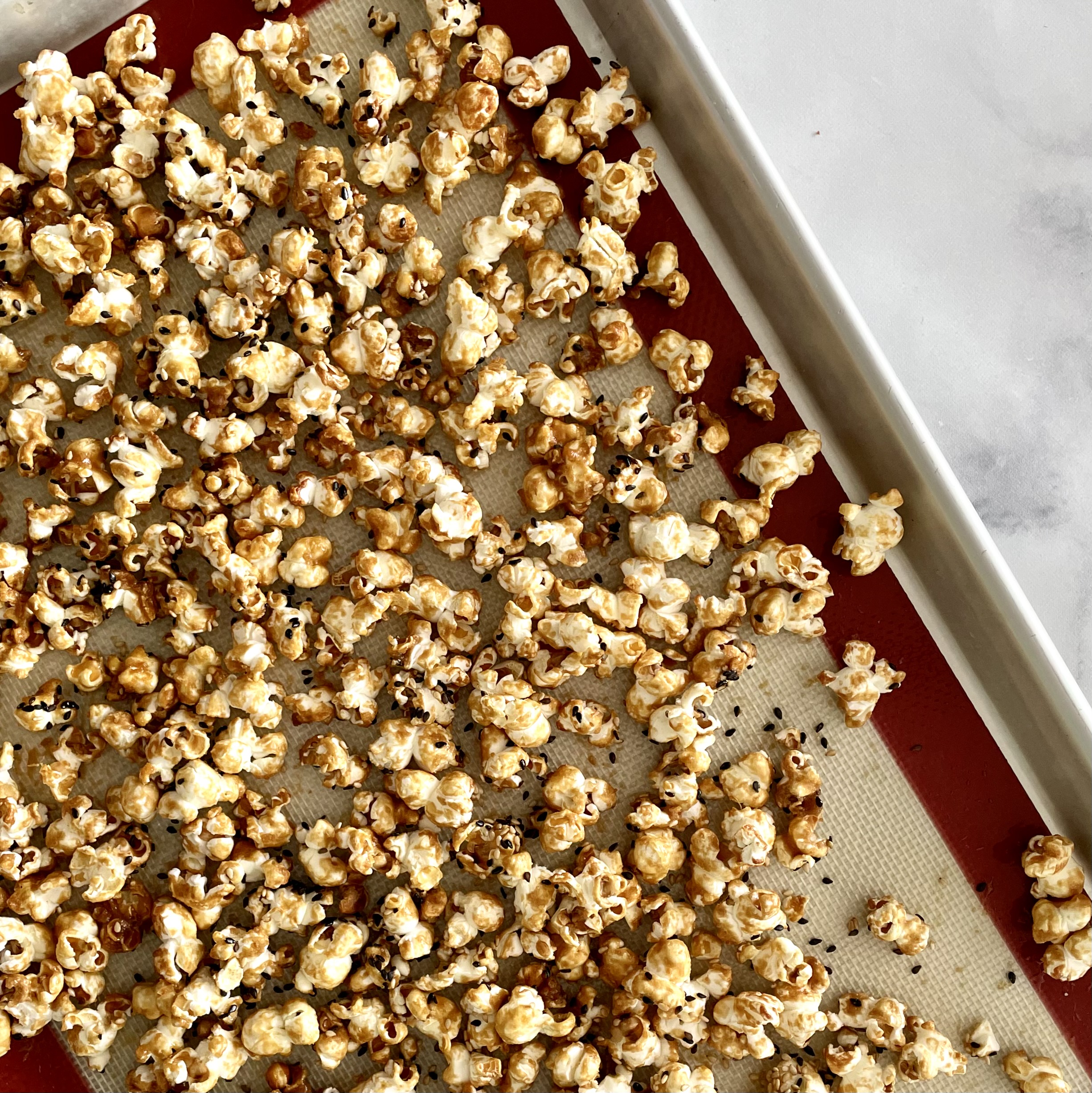 Sweet & Salty Tahini Popcorn right out ow own on a silpat lined rimmed baking sheet