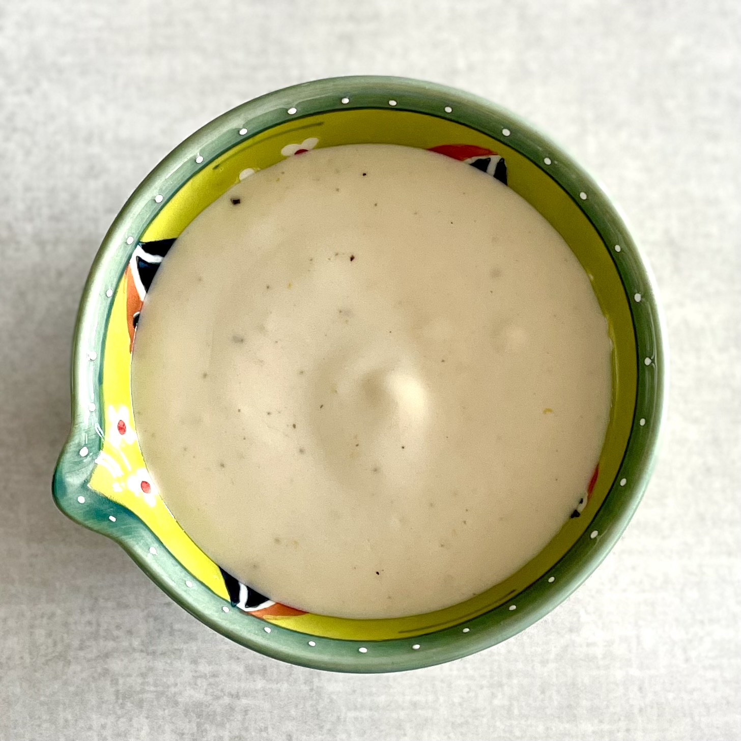 creamy plant-based lemony yogurt sauce in Mediterranean bowl