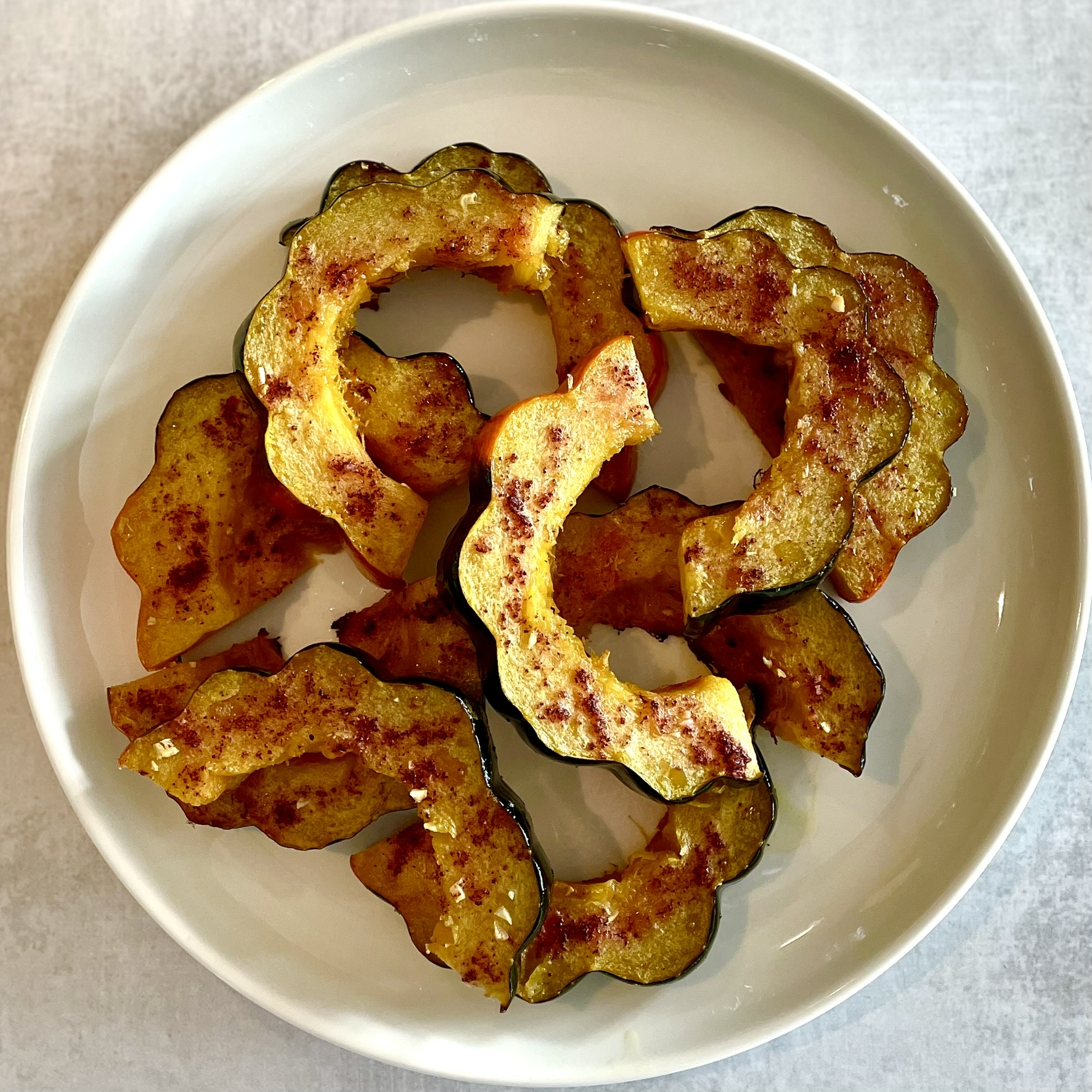 roasted acorn squash slices on a white plate
