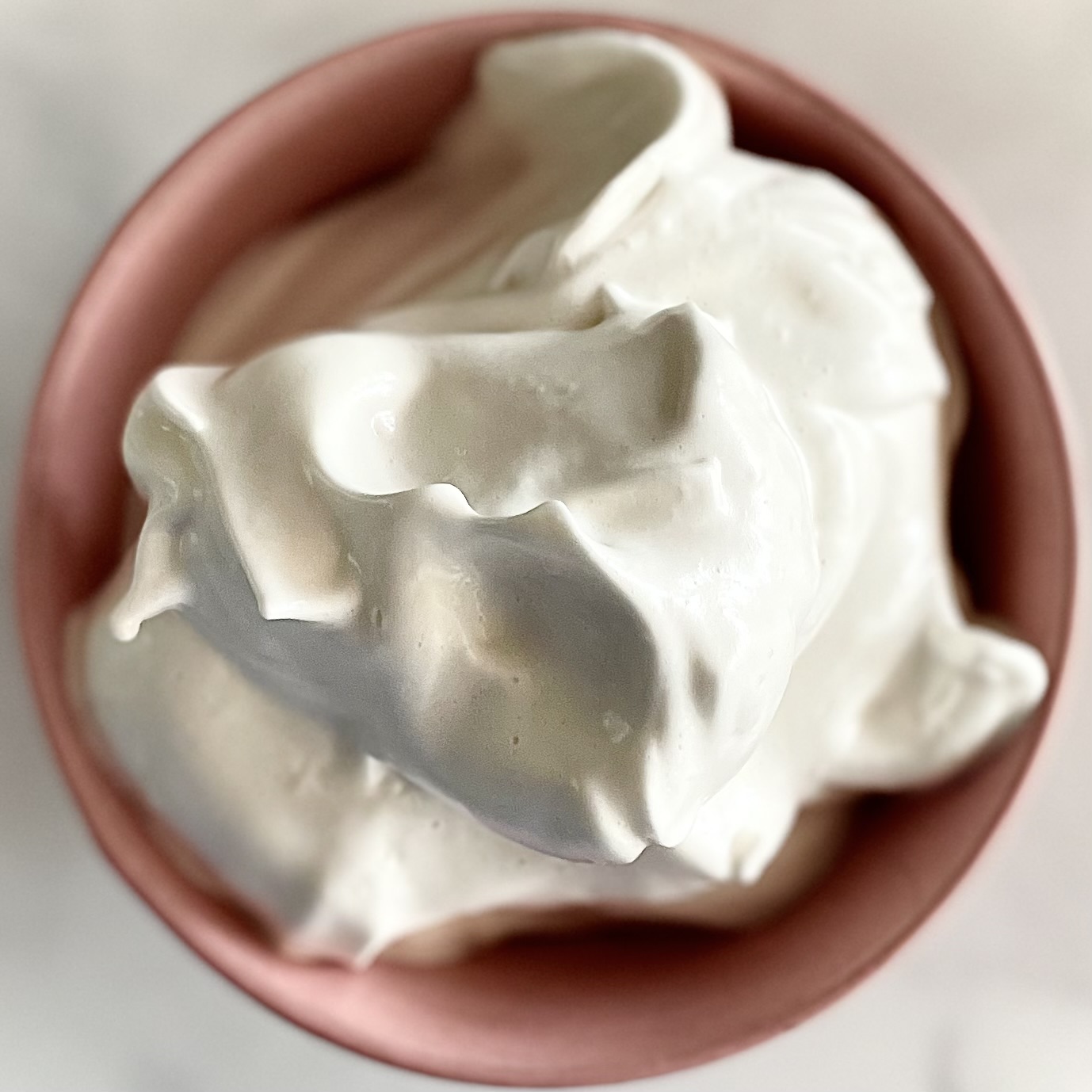 vanilla aquafaba whipped cream in a pink bowl