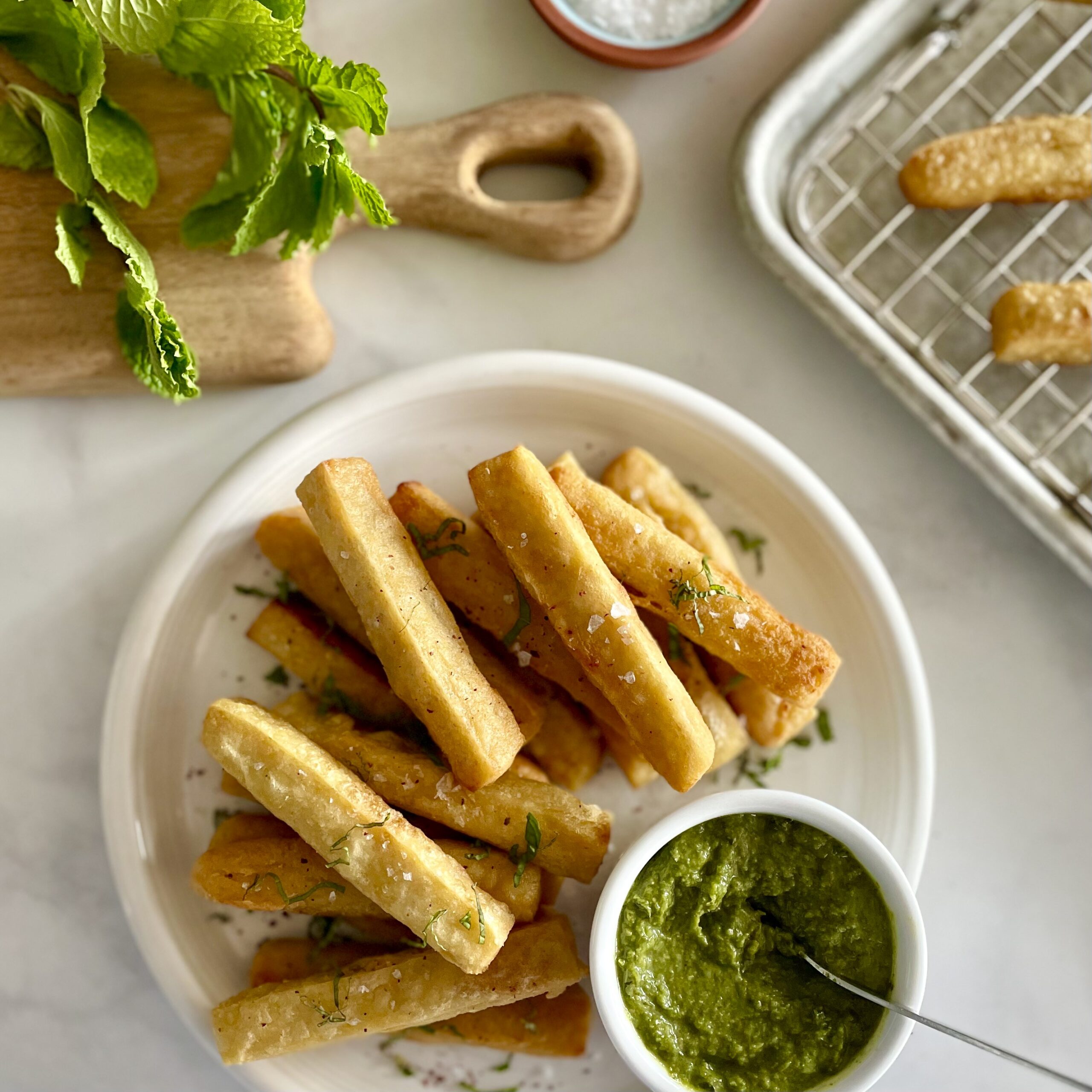 closeup of chickpea fries with zhoug with mint in background