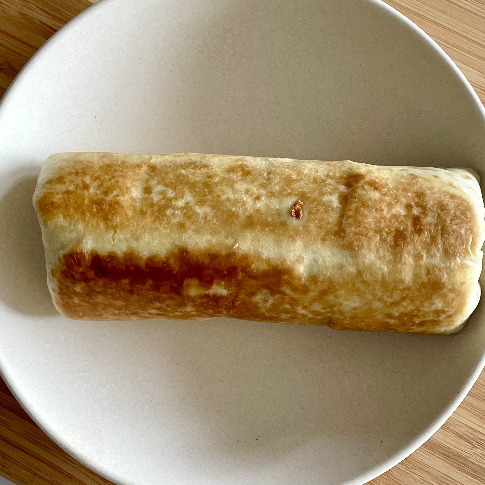 crispy burrito before topping it in a flat bowl
