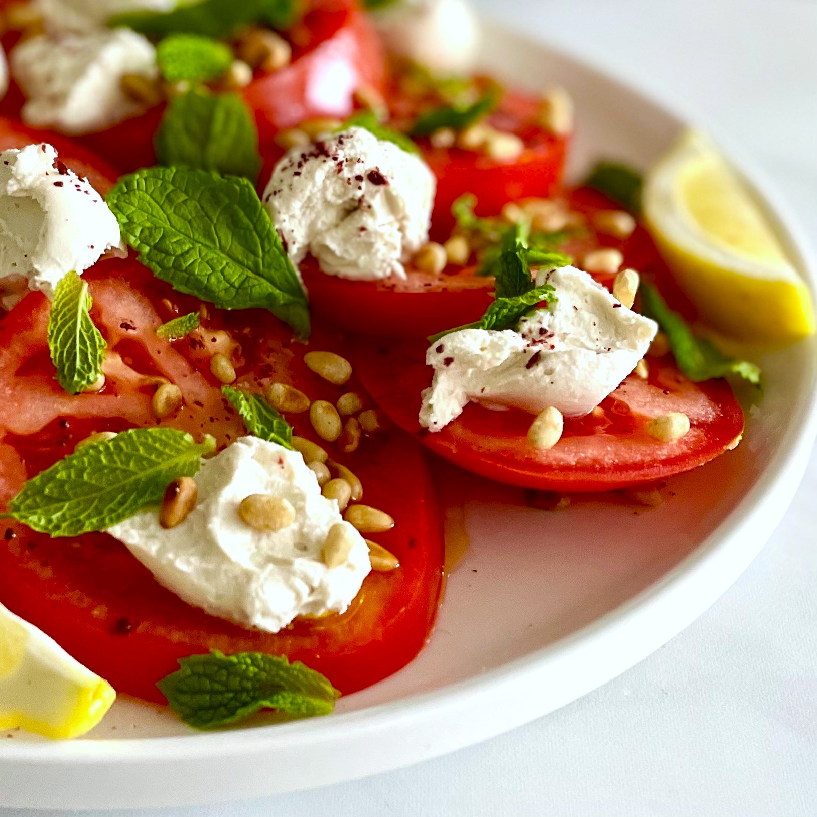 side view of caprese-style salad with pine nuts, mint and lemon
