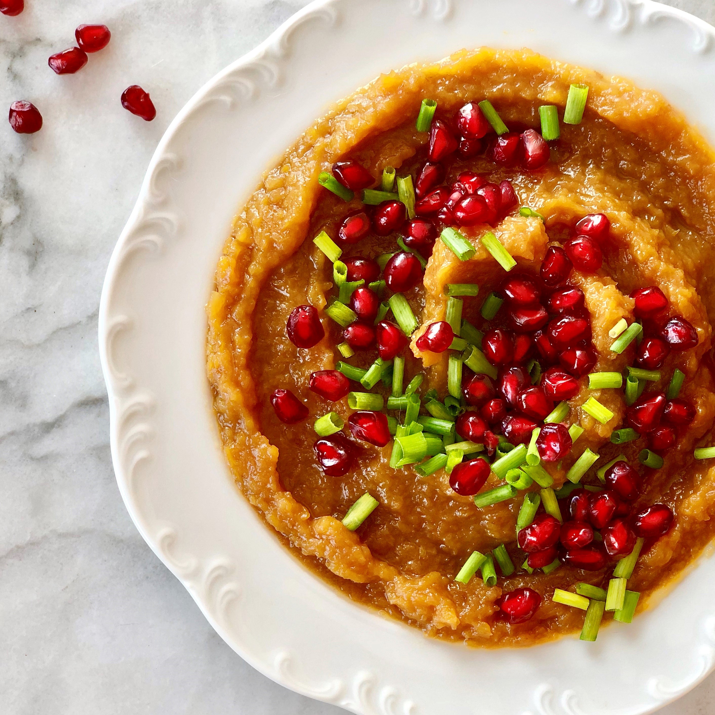Smashed butternut squash with pomegranate arils and chives