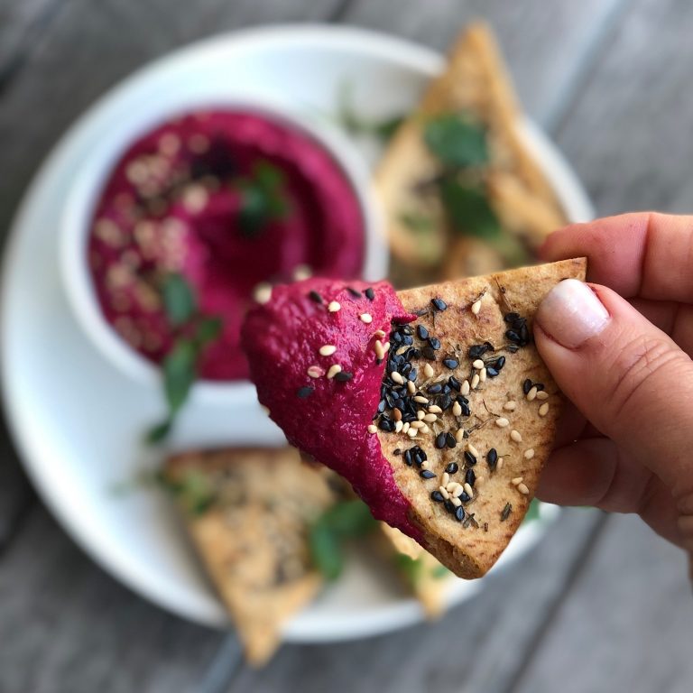 scooping up beet dip with pita chip