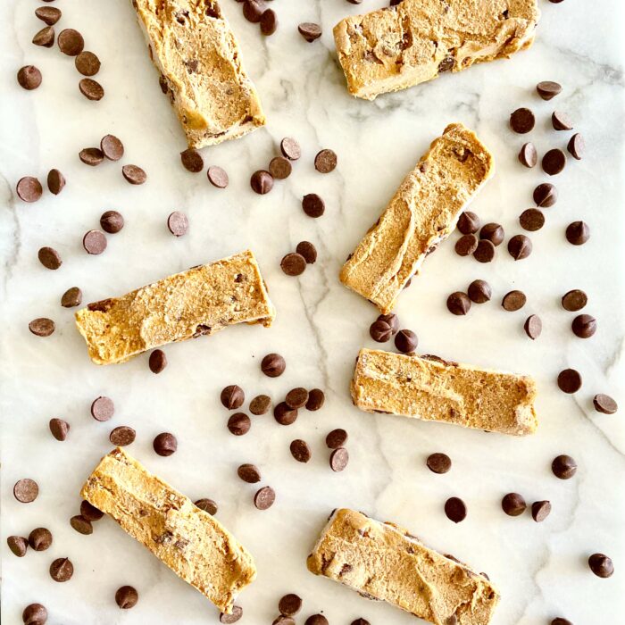 frozen chocolate chip chickpea cookie dough snack bars on white marble with chocolate chips