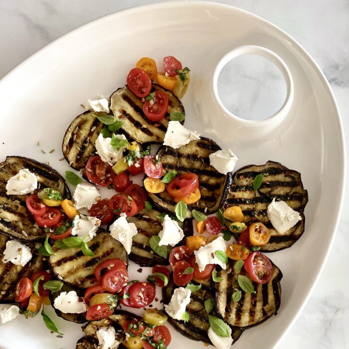 grilled eggplant carpaccio with tomato-basil salsa & treenut cheese on white platter