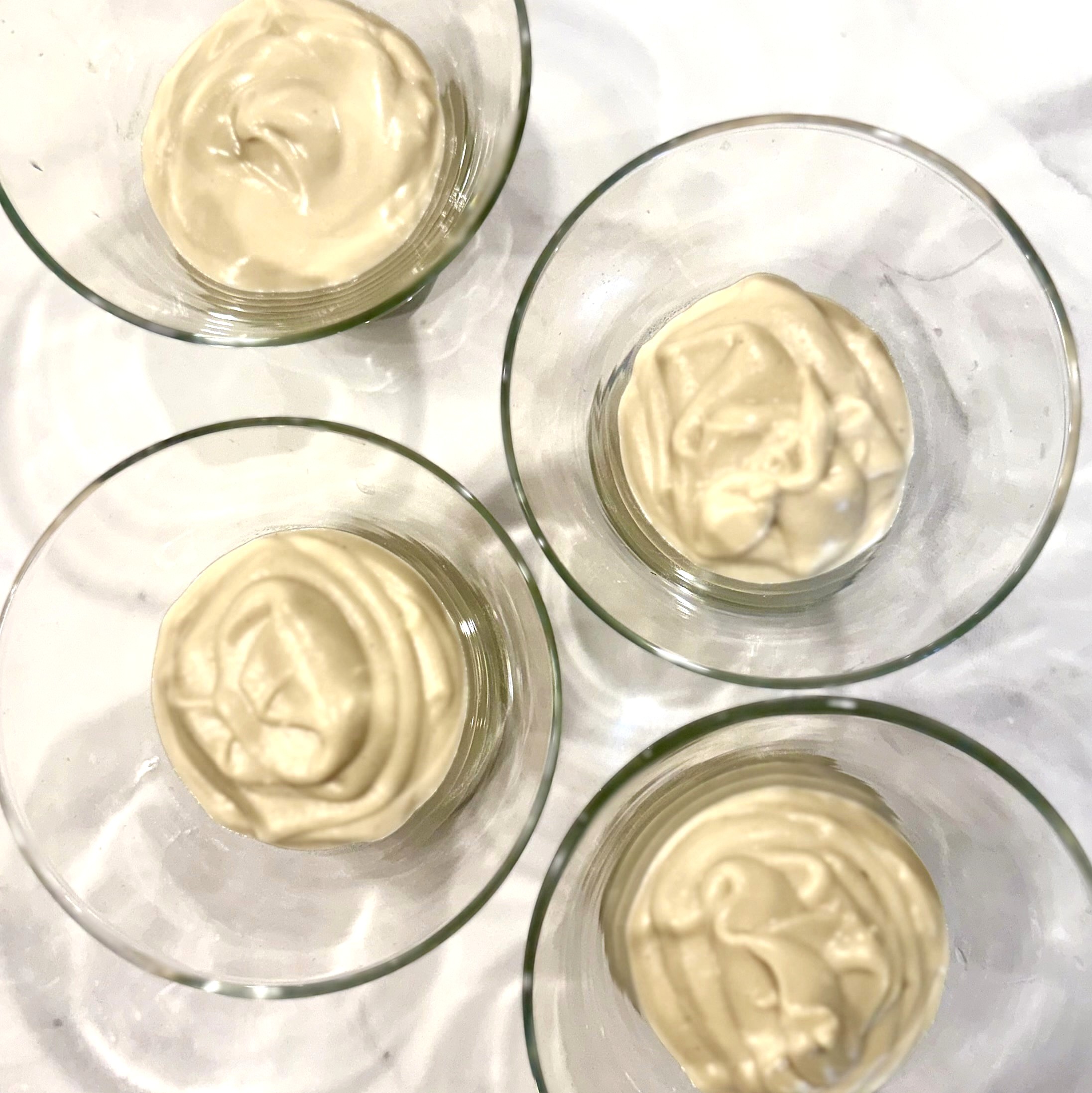 four martini glasses with vanilla pudding